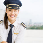 Female pilot with aviator hat and captain stripes.
